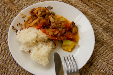 rice and vegetable stew with chicken meat on a white plate. Home cooked food. Asian recipes