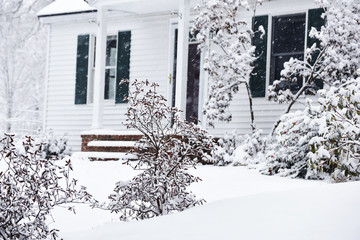 a small cozy house covered with snow during the snowfall. The atmosphere of winter comfort and...