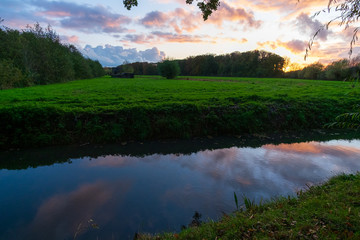 sunset over field and canal