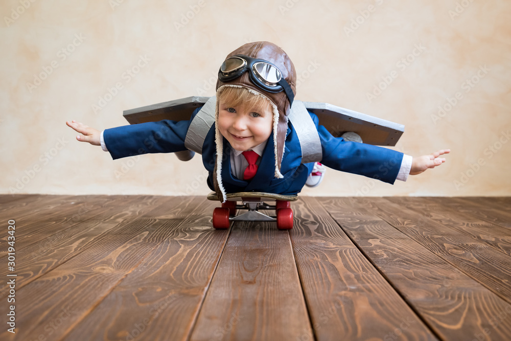 Wall mural Portrait of young businessman with toy paper wings