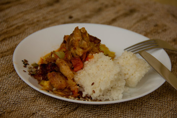 rice and vegetable stew with chicken meat on a white plate. Home cooked food. Asian recipes