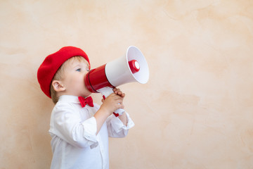 Child shouting through vintage megaphone