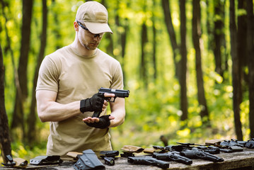 guy in the woods tests his weapons for shooting sports
