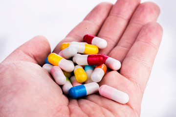 Capsule on hand on white background