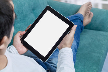 Man hand holding tablet lying on sofa ordering online on touch screen. Delivery service shopping concept for order online. Business and technology with lifestyle in city.