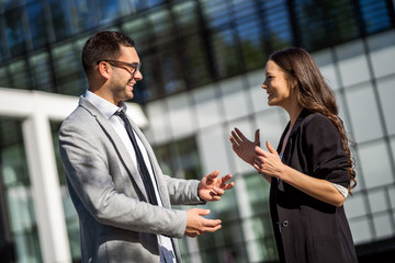 Business colleagues are talking outside the company building.