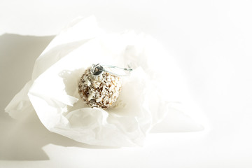 Energy ball in spruce paper on a white background. Edible Christmas ball. Health for Christmas