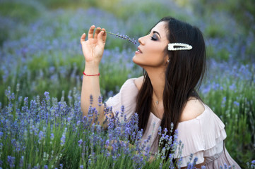 Fototapeta premium Beautiful girl on the lavender field. Beautiful woman in the lavender field on sunset. Soft focus. Series.