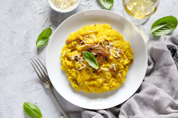 Traditional Italian risotto with mushrooms, saffron and parmesan cheese. Top view with copy space.