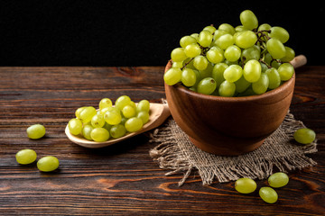 Green grape on dark wooden background.