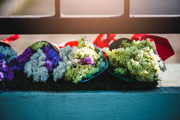 A bouquets of colorful flowers that the trader put on the fence of the educational institution to allow people to buy to congratulate the graduation.