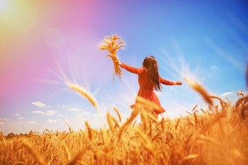 Happy woman enjoying the life in the field Nature beauty, blue sky and field with golden wheat. Outdoor lifestyle. Freedom concept. Woman jump in summer field - 301948621