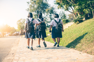 The Asian female high school students in white uniform are going back home after school .