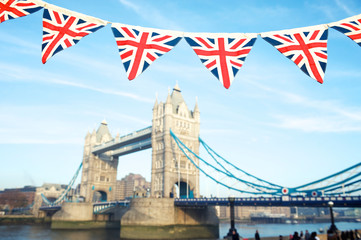 Fototapeta na wymiar Classic blue sky view of Tower Bridge with vintage Union jack pennant bunting in London, UK