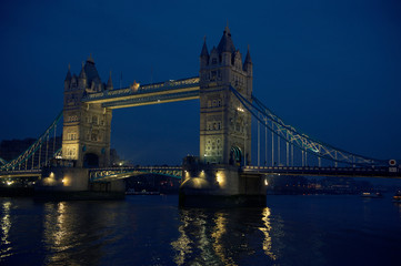 Scenic evening view of Tower Bridge with lights reflecting on the River Thames in London, UK
