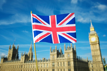 Fototapeta na wymiar Single Union Jack flag waving in front of Big Ben at the Houses of Parliament in London, UK on a clear sunny day