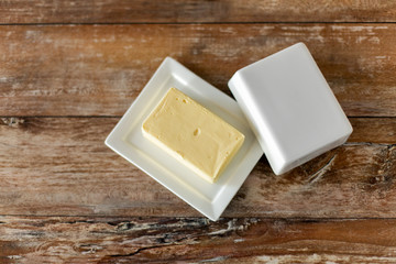 food and dairy products concept - close up of butter on wooden table