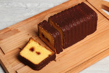 Fototapeta na wymiar Chocolate glazed loaf cake with strawberry jam