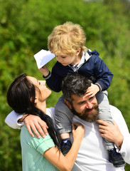 Happy family - mother, father and son on sky background in summer. Happy family - child son playing with paper airplane. Dream of flying. Cute boy with parents playing outdoor.
