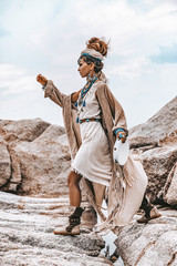 young tribal style woman with lot of boho accessories outdoors