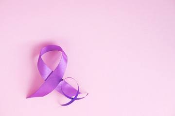  Two purple ribbons on pink paper background. Alzheimer's disease, Pancreatic cancer, Epilepsy awareness, hope, world cancer day. Top view, copy space.  Selective focus.               