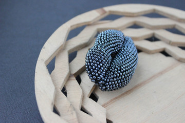 lip-shaped bead brooch on a wooden carved plate