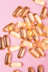 Close up vitamin C capsules on pink isolated background.