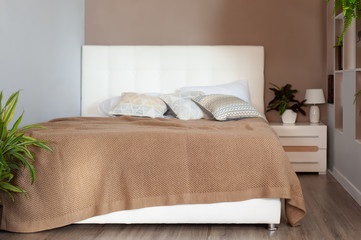 Fototapeta na wymiar beige knitted blanket on bed in cozy bedroom