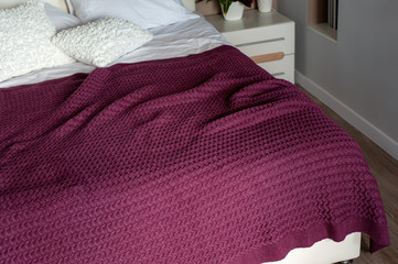 Marsala color knit blanket on bed in cozy bedroom