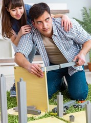 Young family assembling furniture at new house