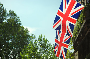 Fototapeta na wymiar Union Jack flag decorations strung above the streets of London, UK under soft blue sky