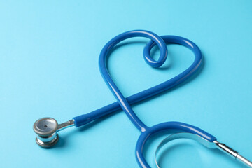 Stethoscope on blue background, space for text