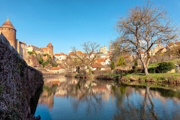 Fototapeta na wymiar View of the city of Semur-An-Osua from the banks of the Armankon River in springtime. There are castle buildings, a riverbank and houses traditional for the region. Burgundy. France.