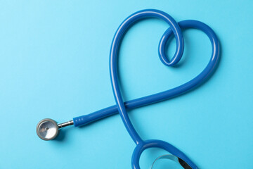 Stethoscope on blue background, space for text