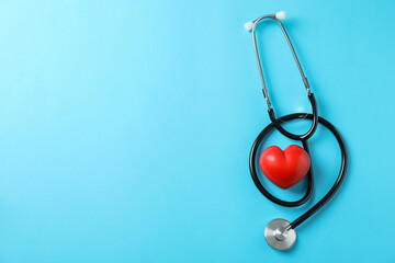 Stethoscope and heart on blue background, space for text. Healthcare