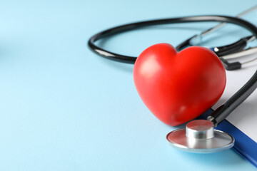 Stethoscope and red heart on blue background, close up. Healthcare