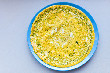 scrambled eggs on a blue plate. strewn with seasonings. view from above. morning breakfast