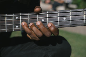 Portrait of African musician bass guitar player outdoors