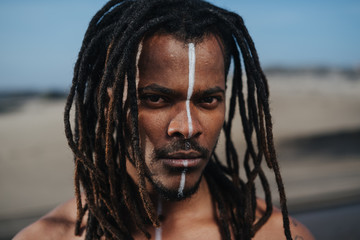 Outdoor emotional Fashion Portrait of African man wearing long dreadlocks and fancy makeup white...