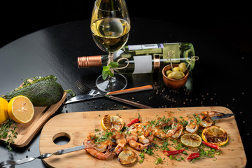 Shrimp shrimp, decorated with herbs, next to the grilled lemons.