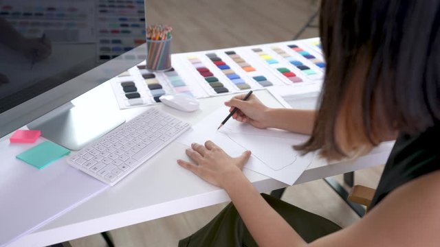 Creative designer drawing and sketching new ideas on paper at working table