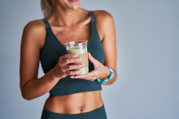 Adult woman drinking healthy smoothie after workout