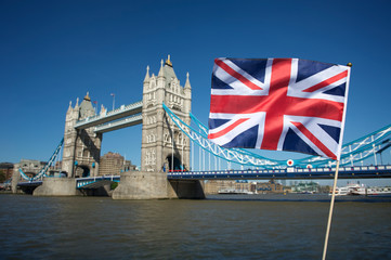 Fototapeta na wymiar British Union Jack flag flying in front of classic blue sky view of Tower Bridge in London, UK