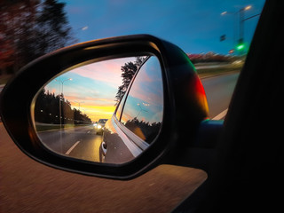Side mirror of the car with amazing sunset