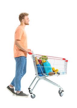 Young man with shopping cart on white background