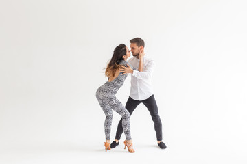 Obraz na płótnie Canvas Social dance, kizomba, tango, salsa, people concept - beautiful couple dancing bachata on white background with copy space