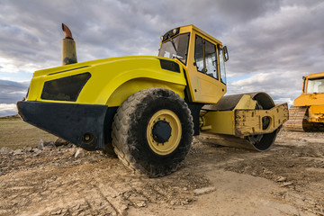 Steamroller performing leveling work on a road under construction