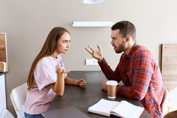 Portrait of dissatisfied angry couple sort out relationship, arguing loudly in bright bed room, tension in the air, indoor shot