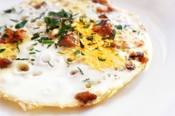 Omelet with eggs, bacon (brisket) and herbs on a white background. Recipe for a healthy diet and breakfast. Close-up.