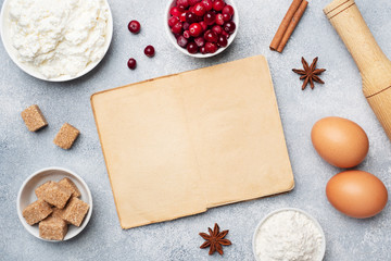 Ingredients for baking cookies, cupcakes and cake. Frame of Raw foods eggs flour sugar cottage cheese cranberries on a grey background with copy space.
